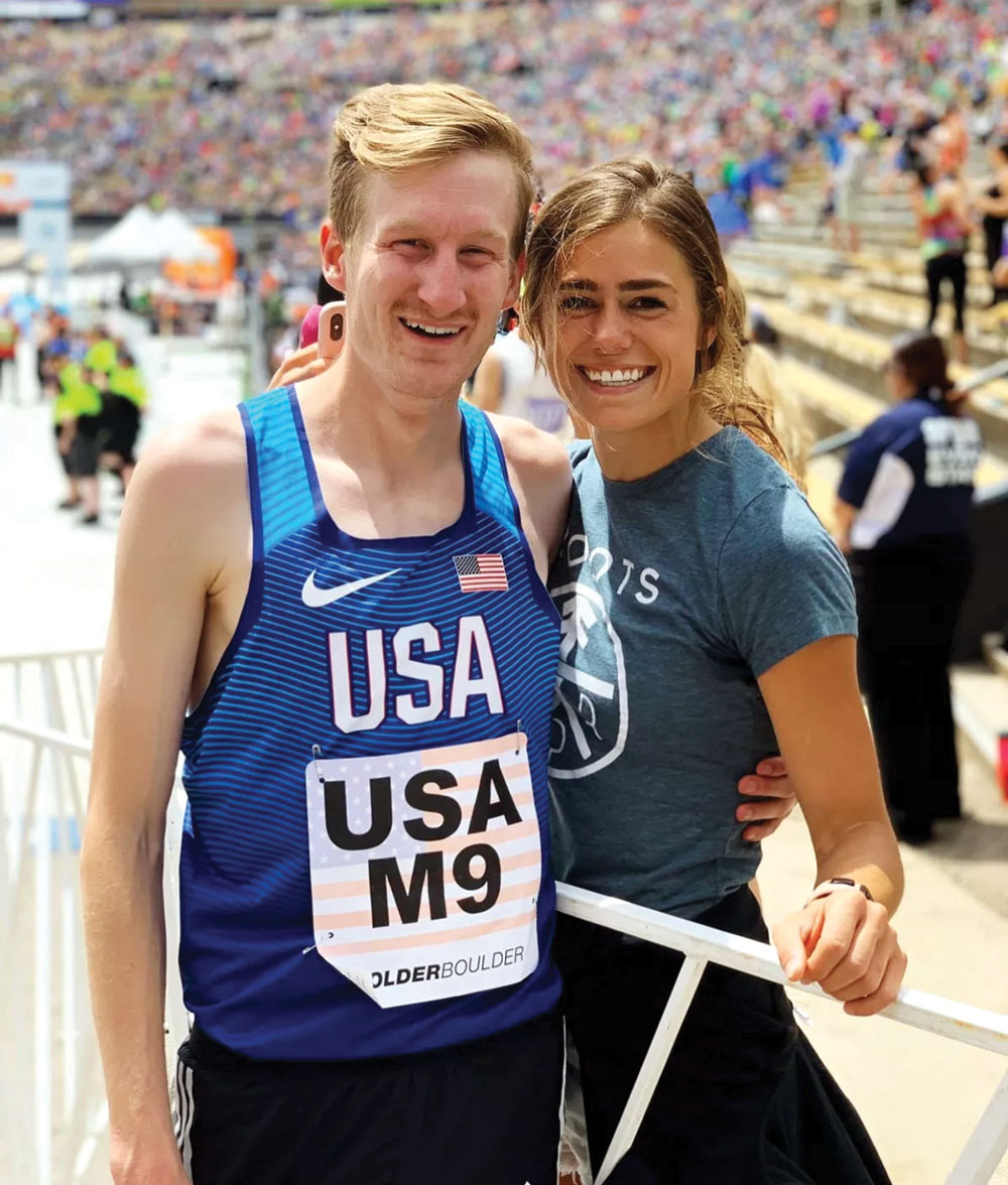Two people smiling at a sports event, one in a "USA" jersey.