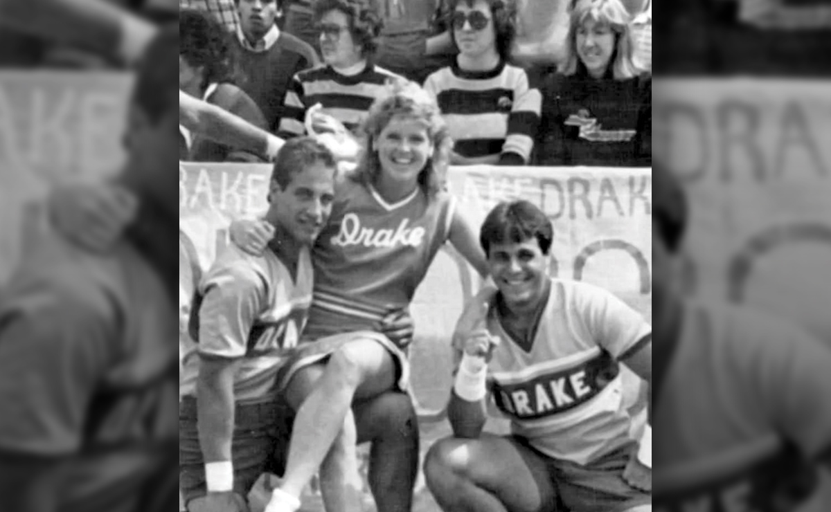 Three people in "Drake" jerseys, with a crowd and Drake banner in the background.