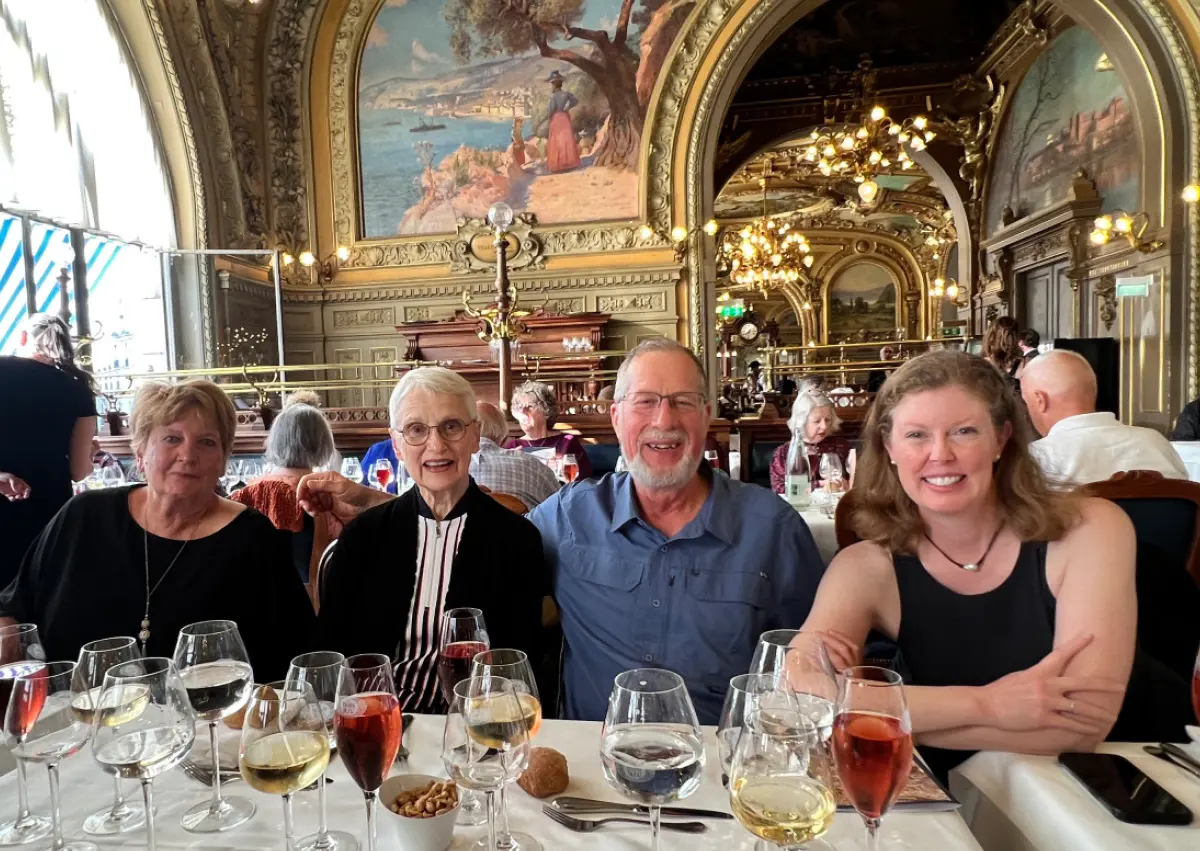 OLLI at Drake University members dining at Le Train Bleu restaurant in Paris, featuring ornate gold leaf decor and large wall murals.