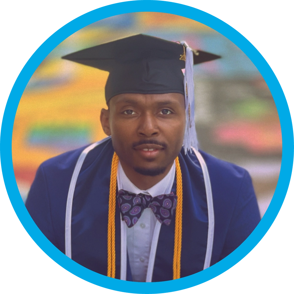 Donovan McCamey wearing a blue graduation gown, a purple patterned bowtie, and a black mortarboard cap with a gold tassel.