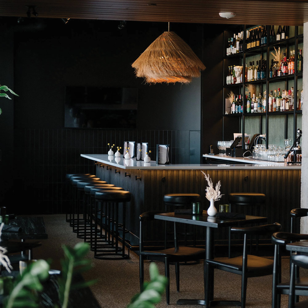 An interior view of this stylish, moody cocktail bar. It’s a popular local "hidden gem" known for its creative drink menu and mid-century aesthetic.