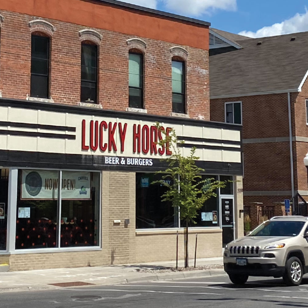The storefront of the restaurant located on University Ave, known for its patio and classic American fare.