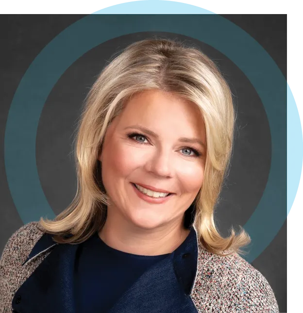 Studio portrait of an adult woman with blonde hair styled in loose layers, wearing a dark top and textured jacket, smiling at the camera against a dark background with a circular graphic element.