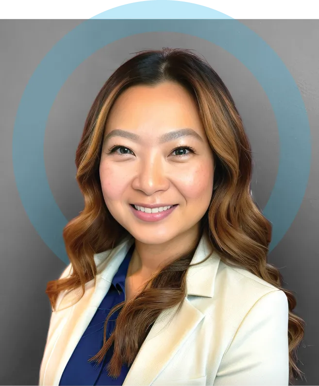 Studio portrait of an adult woman with long wavy hair wearing a light-colored blazer over a dark top, smiling at the camera against a neutral background with a circular graphic element.