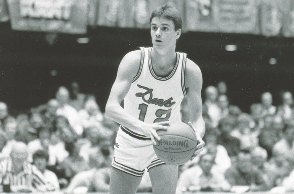 Vintage black-and-white photo of Doug Lampe wearing jersey number 12 holding a Spalding ball.