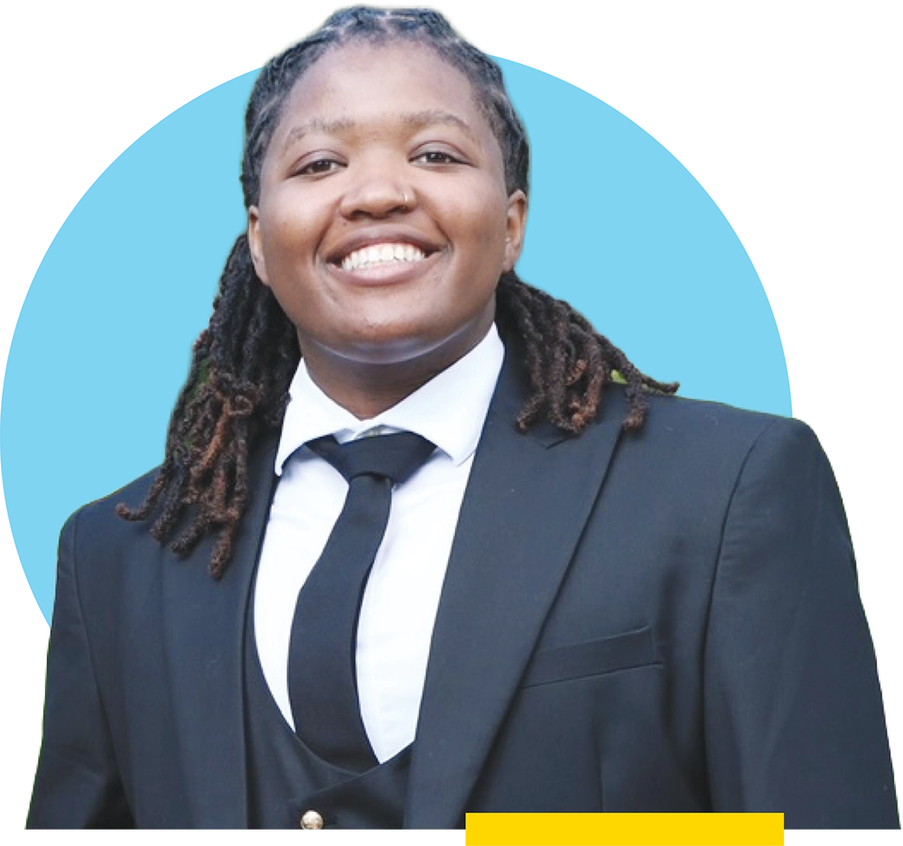 Ty Walls smiling in a black three-piece suit against a blue circle background.