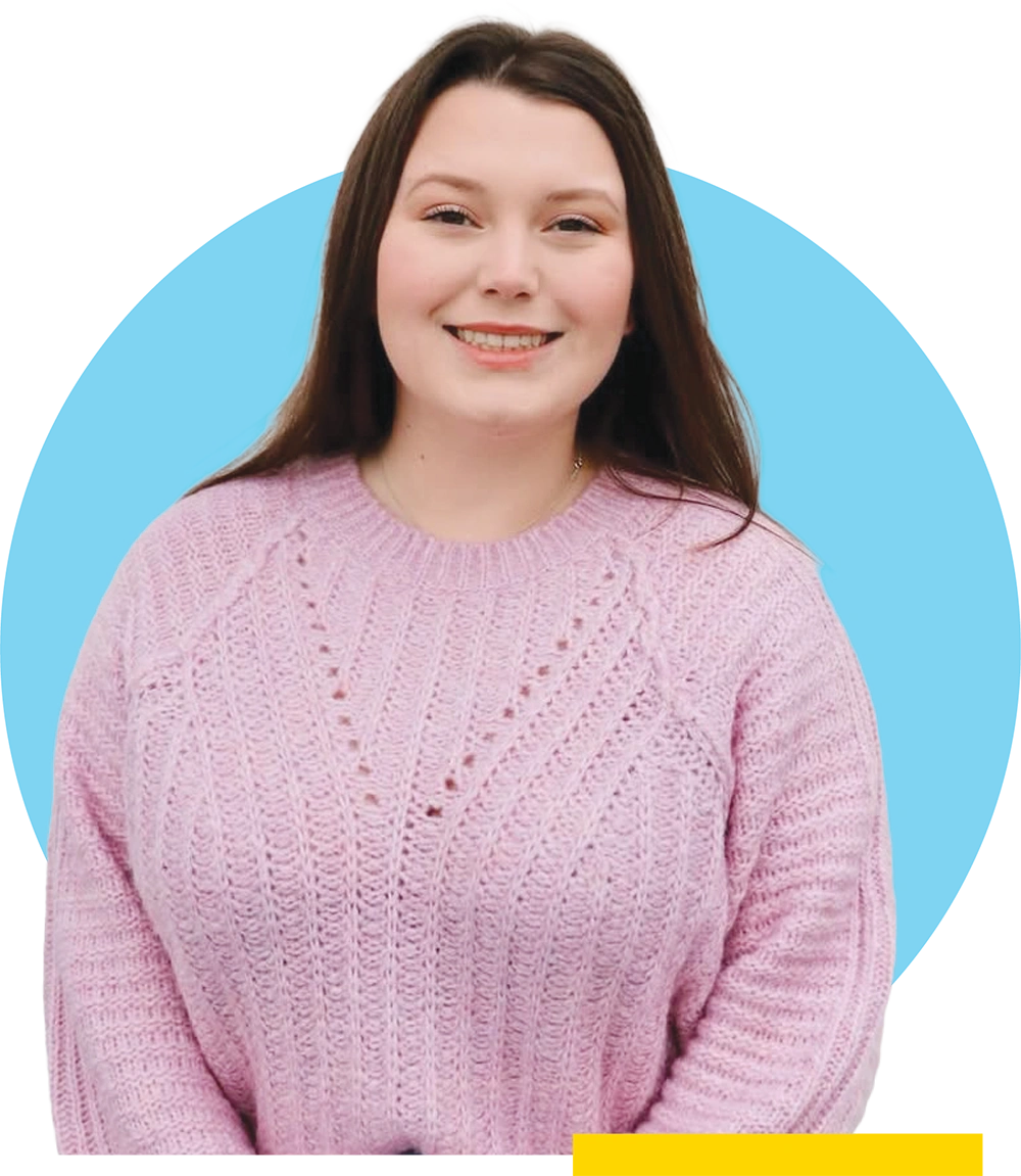 Keira O’Brien wearing a pink sweater against a light blue background.