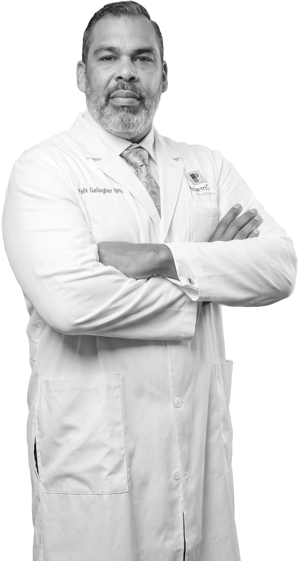 Black-and-white studio portrait of Felix Gallagher with arms crossed wearing a white lab coat over a tie.