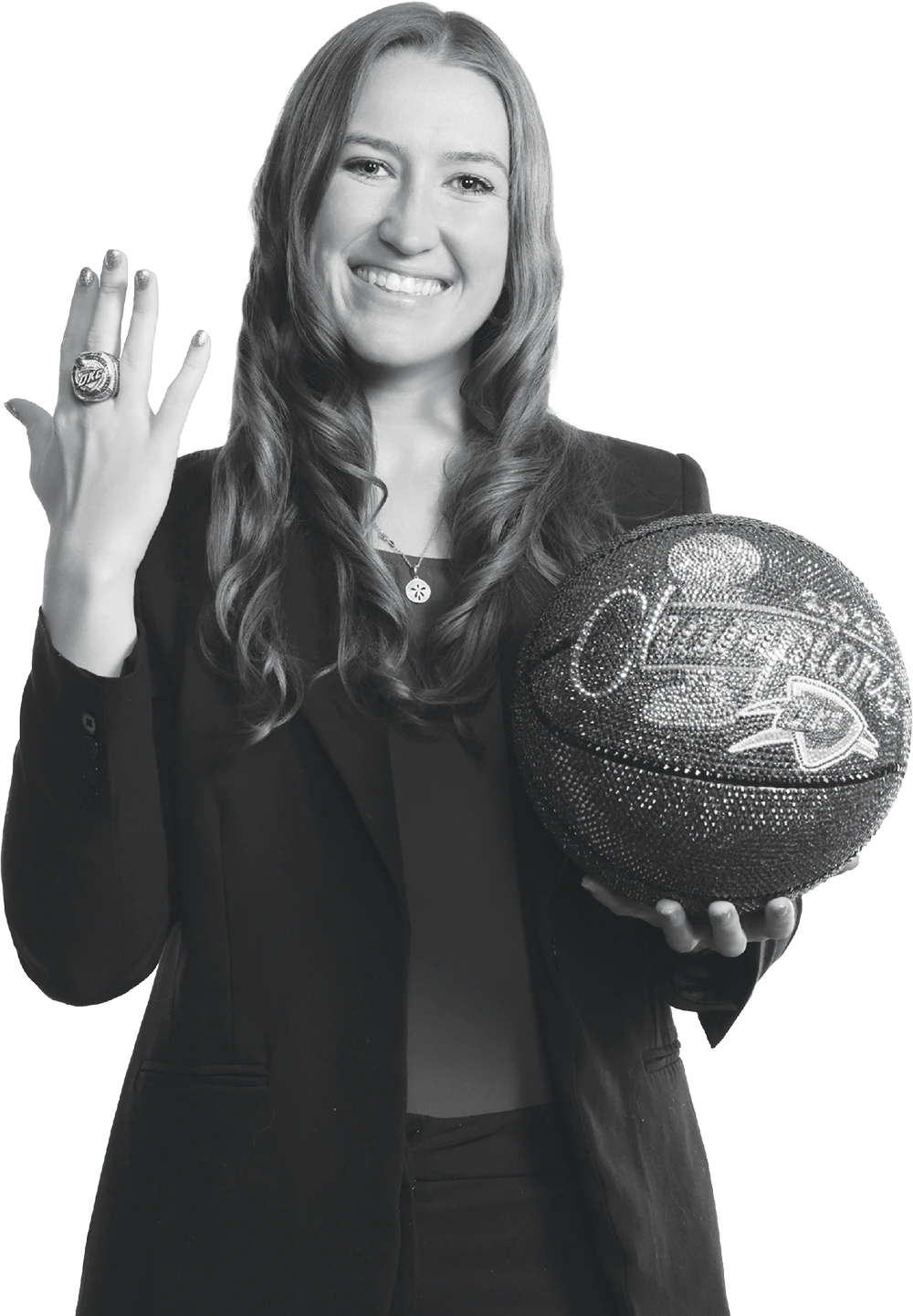 Black-and-white photo of a smiling Kendall Hunt holding a jeweled basketball and showing off a championship ring.